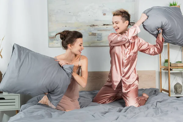Excited Pangender People Pillows Having Fun Fighting Bedroom — стоковое фото