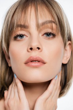 close up of woman with blue eyes looking at camera isolated on white