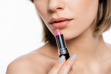 cropped view of young woman holding pink lipstick isolated on white
