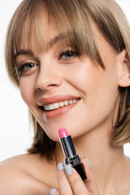 Pembe ruj tutan kâküllü genç bir kadın beyaz üzerinde izole edilmiş.