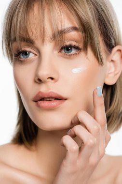 Yanağında krem ve kâhkülleri olan genç bir kadın, beyaz tenli, gözlerden uzak. 