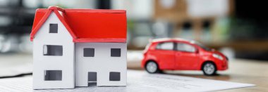 karton ev modeli ve oyuncak araba belgede, pankartta