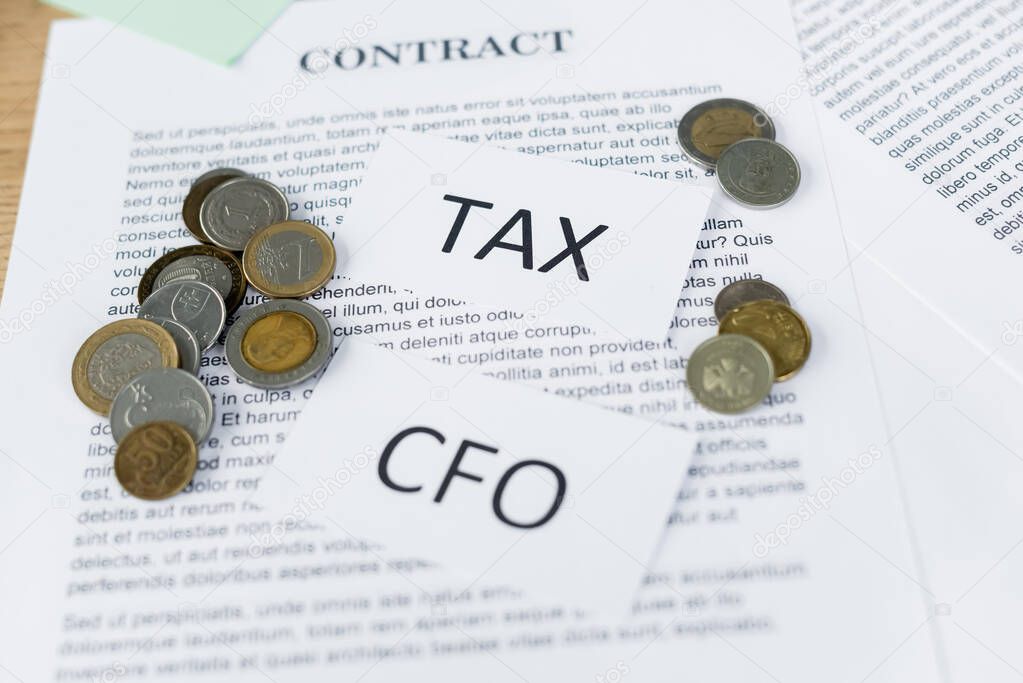 papers with tax and cfo lettering on contract with coins 