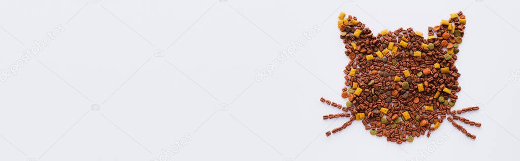 top view of shape of cat made from dry pet food isolated on white, banner