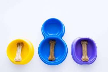 Beyaz tenli renkli kâselerde leziz kemik şekilli ikramların üst görüntüsü