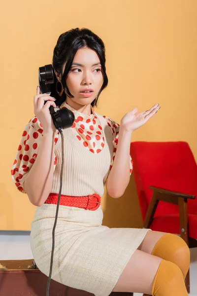 Trendy Asian Woman Talking Telephone Retro Suitcase Orange Background — Stock Photo, Image