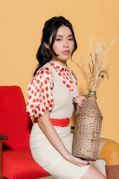 Trendy Asian Woman Blouse Dress Holding Vase Spikelets While Sitting — Stock Photo, Image