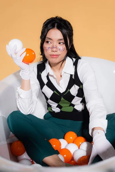 Stylowa Azjatycka Kobieta Rękawiczkach Kulkami Wannie Odizolowana Pomarańczowo — Zdjęcie stockowe