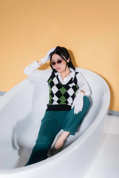 Trendy Asian Model Sunglasses Posing Bathtub Orange Background — Stock Photo, Image