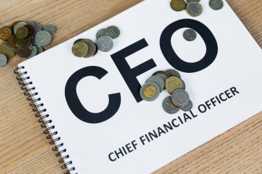 close up view of coins near notebook with cfo lettering on desk clipart