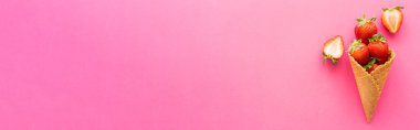 Pembe arka planda lezzetli waffle külahında taze çilek manzarası, afiş. 