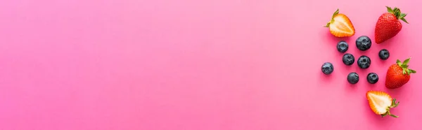 粉色背景下带有复制空间 横幅的有机浆果的顶部视图 — 图库照片