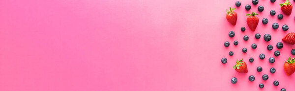 Плоская лежала с клубникой и целыми черниками на розовом фоне, баннер 