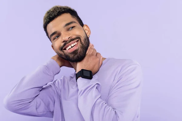 bearded african american man in sweater smiling isolated on purple