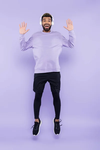 Longitud Completa Hombre Afroamericano Excitado Auriculares Inalámbricos Saltando Sobre Púrpura — Foto de Stock