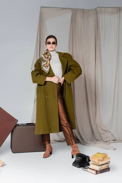 Trendy Woman Green Coat Posing Suitcases Retro Phone Books Grey — Stock Photo, Image