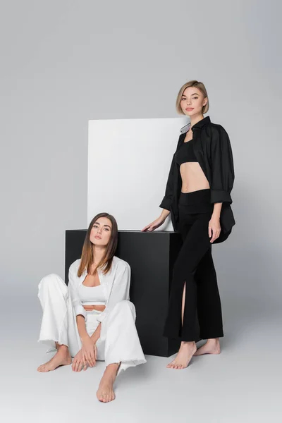 Modelos Descalzos Camisas Pantalones Posando Cerca Cubos Blancos Negros Sobre — Foto de Stock