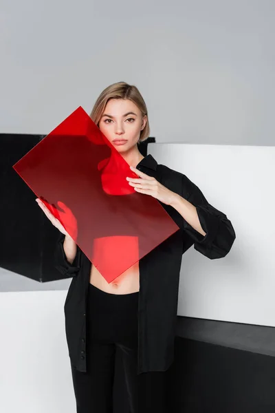 Mujer Elegante Con Vidrio Rojo Mirando Cámara Cerca Cubos Negros — Foto de Stock