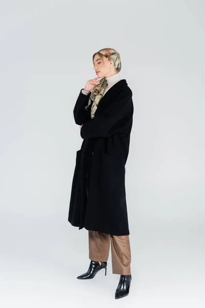 Full Length Woman Kerchief Black Coat Touching Chin Grey Background — Stock Photo, Image