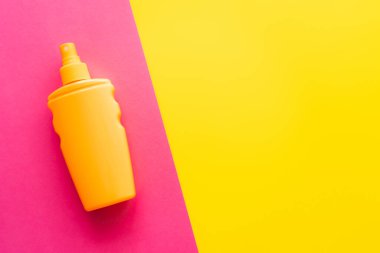 Pembe ve sarı arkaplanda güneş kreminin üst görünümü 