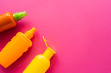 Pembe yüzeyde, fotokopi alanı olan güneş kremlerinin üst görünümü