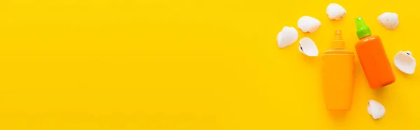 黄色の背景に日焼け止めの近くの貝殻のトップビュー バナー — ストック写真