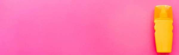 粉色表面橙色防晒霜瓶顶视图 带有复制空间 — 图库照片