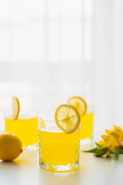 Beyaz arka planda limon dilimli ev yapımı narenciye suyu.
