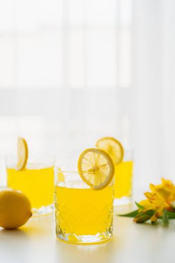 glasses of homemade citrus juice with lemon slices on white background clipart