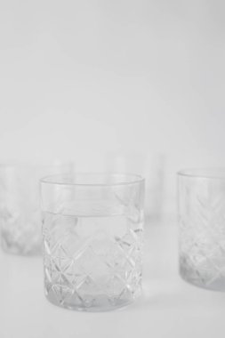 Gri arkaplanda su bulunan şeffaf camların seçici odağı