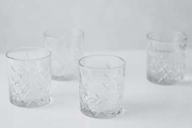 boş yüzlü kristal bardaklar beyaz masa üstünde izole edilmiş gri üzerinde