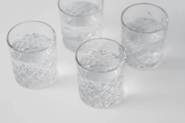 Vista Ángulo Alto Agua Vasos Con Patrón Facetado Superficie Blanca —  Fotos de Stock