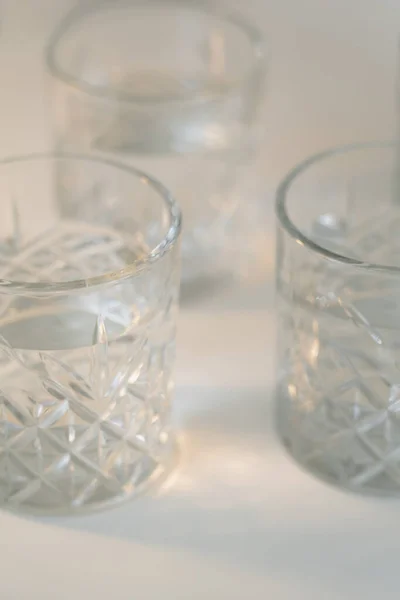 Close View Faceted Glasses Clean Water Blurred Grey Background — Stock Photo, Image