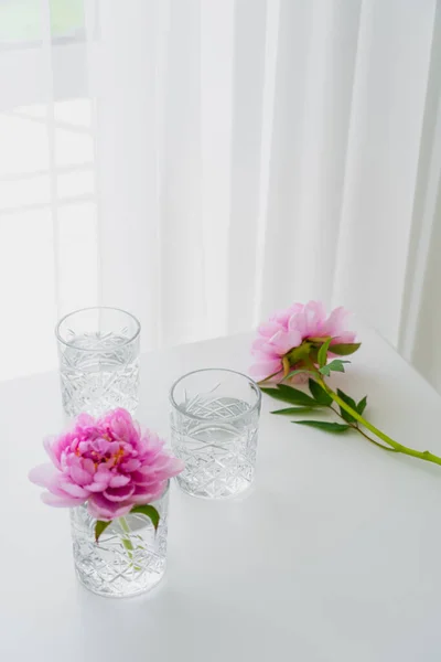 Vidrios Facetados Transparentes Peonías Rosadas Mesa Blanca Cerca Cortina — Foto de Stock