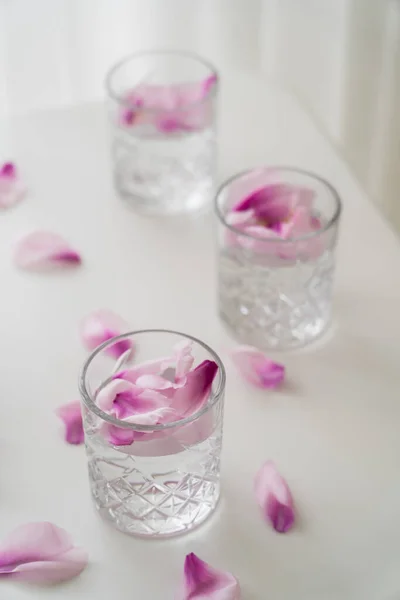 High Angle View Faceted Glasses Tonic Natural Petals White Surface — Stock Photo, Image