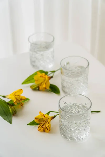 Vasos Cristal Con Agua Cerca Flores Alstroemeria Amarillas Sobre Mesa — Foto de Stock