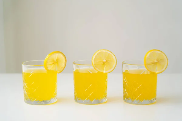Slices Fresh Lemon Glasses Natural Citrus Juice White Surface Isolated — Stock Photo, Image