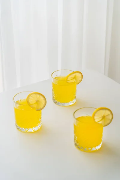 Gläser Erfrischende Limonade Mit Scheiben Reifer Zitrone Auf Weißer Tischplatte — Stockfoto