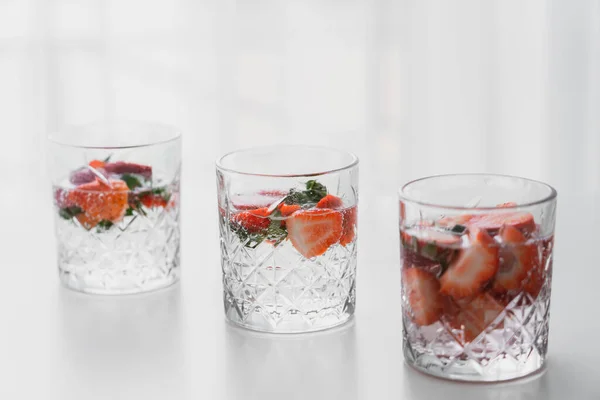 Vasos Transparentes Bebida Tónica Con Fresas Picadas Superficie Blanca — Foto de Stock