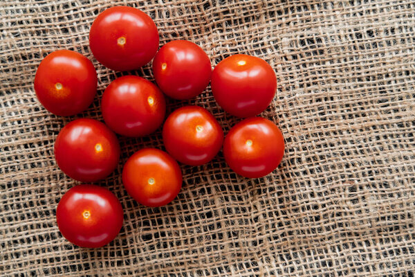 Top view of fresh cherry tomatoes on sackcloth 