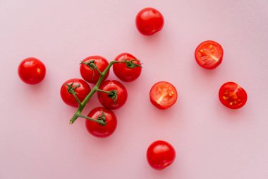 Bütünün üst görüntüsü ve pembe arka planda kiraz domatesleri 