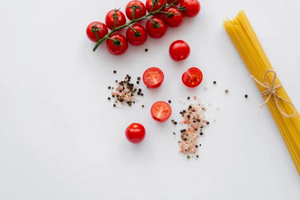 Ovanifrån Körsbär Tomater Nära Kryddor Och Makaroner Vit Bakgrund — Stockfoto