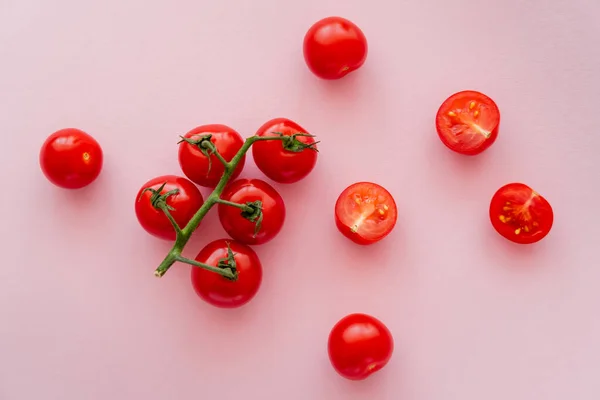 Ovanifrån Hela Och Skär Körsbärstomater Rosa Bakgrund — Stockfoto