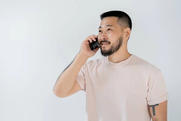 Sonriente Asiático Hombre Con Tatuajes Hablando Smartphone Aislado Gris — Foto de Stock