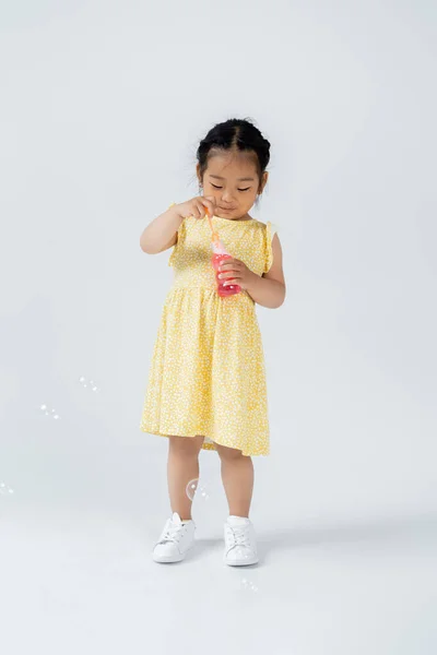 Longitud Completa Niño Preescolar Asiático Vestido Amarillo Celebración Botella Con — Foto de Stock