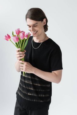 Gri laleler tutan mutlu stil sahibi adam. 