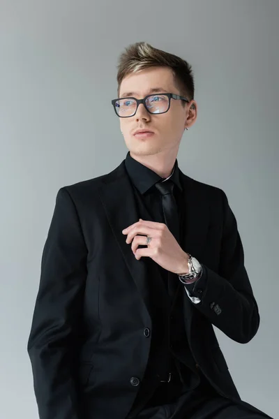 Elegantní Muž Obleku Brýlích Odvrací Pohled Izolované Šedé — Stock fotografie