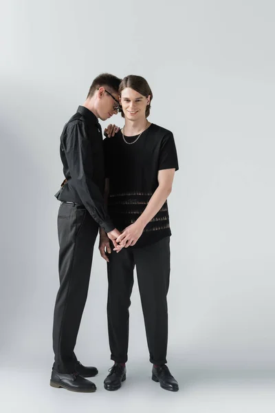 Full Längd Glada Homosexuella Par Svarta Kläder Håller Händerna Grå — Stockfoto