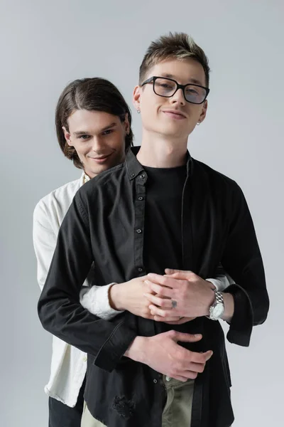 Morena Gay Abrazando Novio Gafas Aislado Gris —  Fotos de Stock