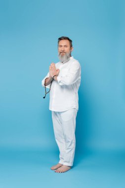 Mavi arka planda dua eden ellerle tespih çeken sakallı ruhani akıl hocası.